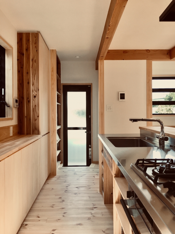 ステンレス天板の造作キッチンはパントリー、勝手口、家事コーナーに隣接