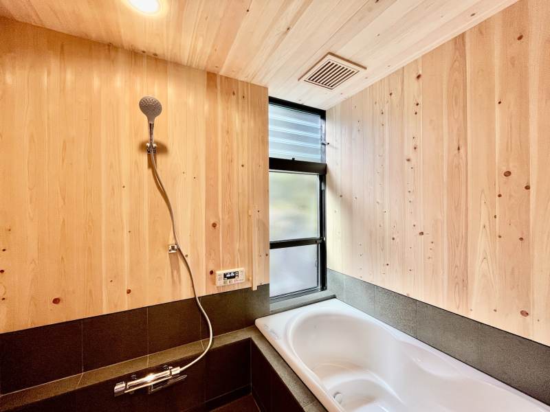 床暖房で冬も暖かく入浴できる御影石と桧羽目板仕上げの在来浴室